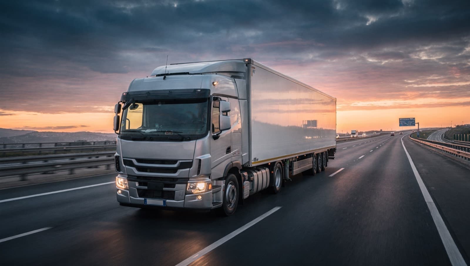 Camión circulando por una autopista europea al atardecer